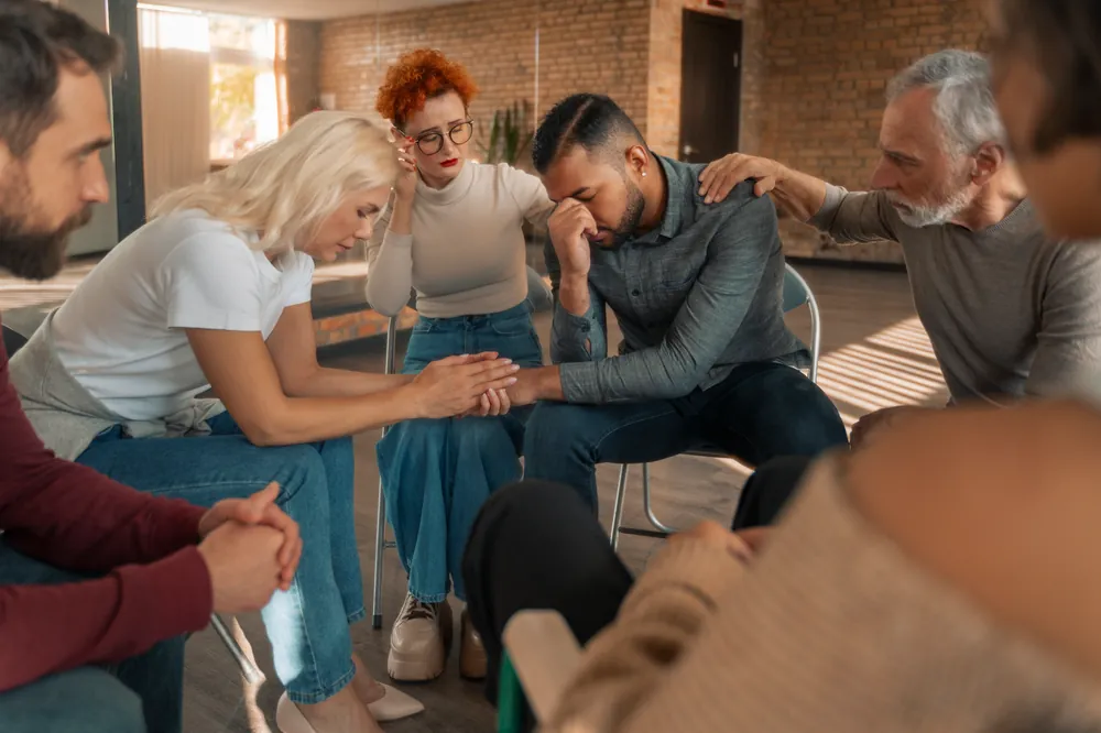 Sesión grupal en Centro Vida Nueva: personas en círculo brindándose apoyo mutuo durante el proceso terapéutico