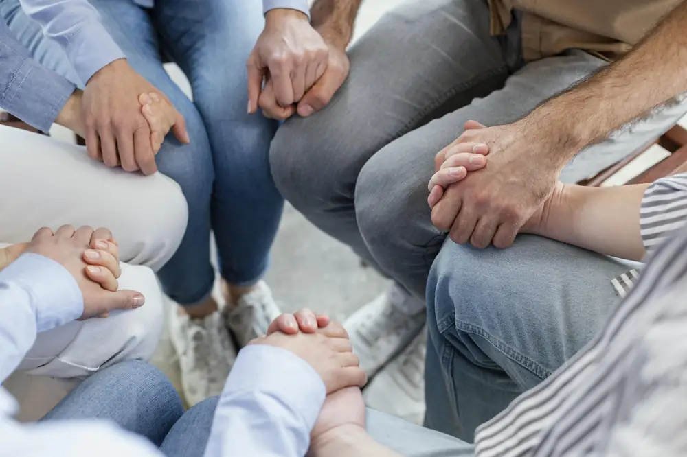 Grupo de personas sentadas en círculo tomadas de las manos durante una sesión de acompañamiento grupal en Centro Vida Nueva